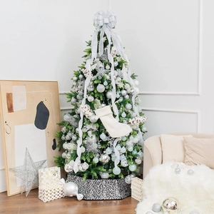 Green Christmas tree with silver decorations and a black and white patterned tree skirt