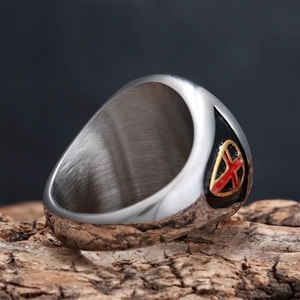 Macro shot of stainless steel shield ring with cross emblem on vintage wood
