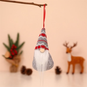 Detail of gray knitted Christmas gnome ornament hanging on a rustic branch with pine cones