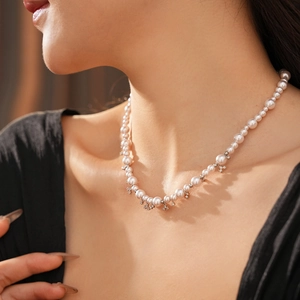 Close-up of pearl necklace with zircon star charms worn by a model in soft light