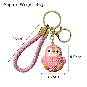 Pink cartoon penguin resin keychain with woven strap and gold lobster clasp charms