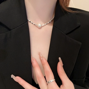 Detail of silver fragmented bead necklace with large freshwater pearl and engraved ring