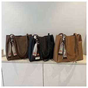 Three minimalist tote bags in brown and black with braided handles and silk scarves