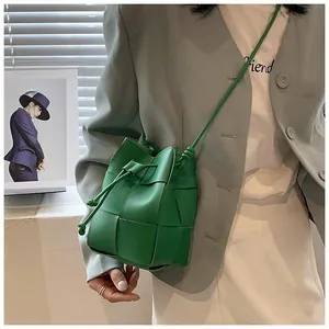 Close-up of green woven leather drawstring bucket bag with Intrecciato pattern