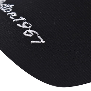 Macro shot of 1967 white embroidery on black washed cotton baseball cap texture