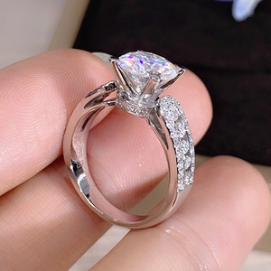 Detailed close-up of a silver ring with six-prong set crystal and side stones