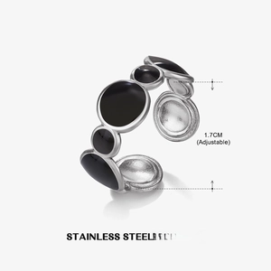 Macro detail of geometric stainless steel ring with black enamel inlay and brushed metal texture
