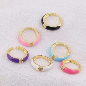 Detail of six colorful enamel open rings with zircon inlay and gold plating
