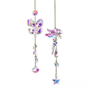 Detail of hanging crystal butterfly and star pendants with golden chains and AB coating