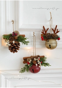 Close-up of Christmas ornaments with pine cones, golden bells, and reindeer antlers