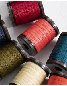 Close-up of 0.4mm round waxed thread spools for leather sewing in multiple vibrant colors
