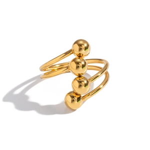 Detail of gold multi-layer spiral ring featuring polished metal beads on a white background