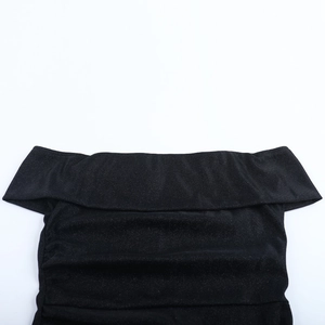 Detailed view of black off-shoulder neckline with shimmering glitter knit fabric texture