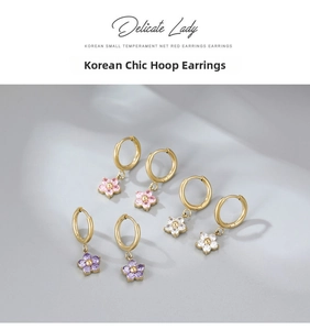 Detailed view of three pairs of flower earrings with pink, white, and purple gemstones