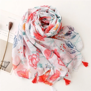 Close-up of lightweight cotton scarf featuring red floral print and bicolor tassel fringe