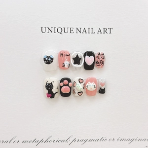 Detailed view of handmade pink and black press-on nails with 3D cat and paw relief art