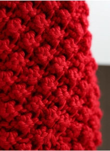 Macro shot of red chunky knit Christmas stocking showing detailed weave texture