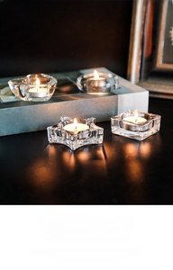 Set of four geometric glass tealight holders in heart, star, square, and round shapes