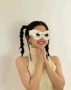 Detail of white plush cat-eye sunglasses with colorful rhinestones on frame