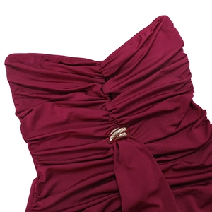 Close-up of ruched dark purple sleeveless dress with golden metal ring detail at the chest