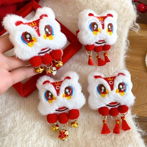 Détail de pinces à cheveux lion chinois en peluche avec broderie et pompons rouges