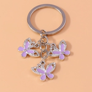 Detail of silver butterfly keychain with purple enamel finish and sparkling crystals