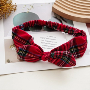 Detail of red plaid bunny ear headband with elastic band on a vintage magazine