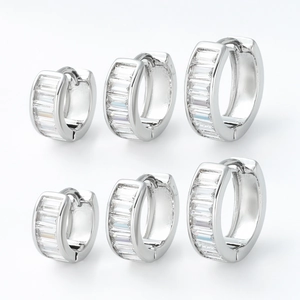 Silver huggie earrings set with baguette cut cubic zirconia stones in three sizes