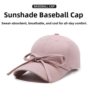 Detailed view of pink cotton baseball cap featuring a decorative ribbon bow on the brim