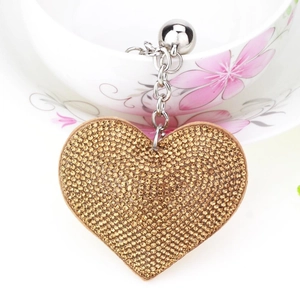 Macro shot of heart-shaped keychain with gold rhinestones and silver metal chain
