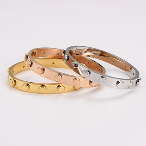 Three-tone stackable stainless steel bracelets with studded rivets in gold and silver