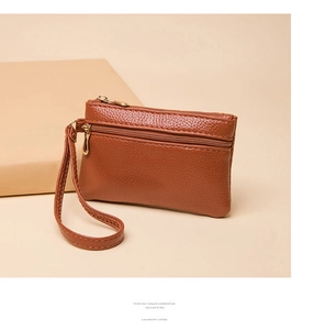 Close-up of caramel brown double zipper coin purse with wristlet and golden hardware