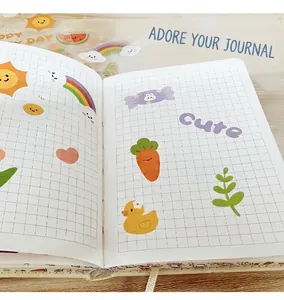 Detail of cute waterproof cartoon stickers with rainbow and heart icons on a grid notebook