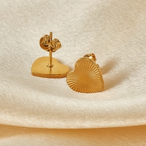 French vintage gold plated heart studs with radial pattern on beige silk background