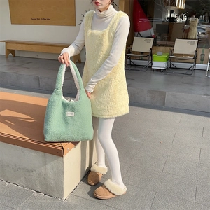 Detailed texture of matcha green fuzzy tote bag with branding tag in winter street style