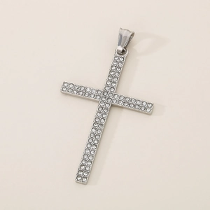 Detailed view of silver cross pendant with sparkling rhinestones on neutral background
