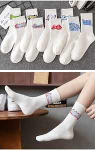 Detail of white cotton mid-calf socks featuring colorful graffiti-style knitted letters