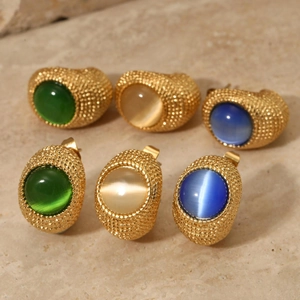 Vintage gold textured stud earrings with cat eye stones in green, blue, and champagne