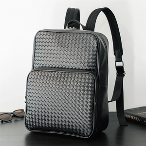 Close-up of black woven leather texture and metal zipper on men's business backpack