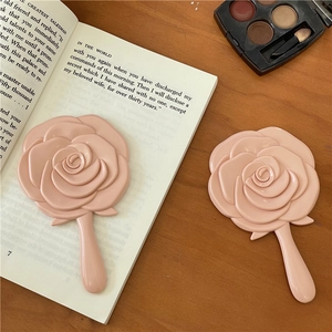 Handspiegel in Form einer rosa Rose, tragbarer Mini-Schminkspiegel auf Holztisch