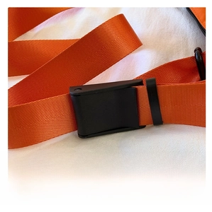 Gros plan sur la sangle en nylon orange avec boucle de réglage robuste en plastique noir