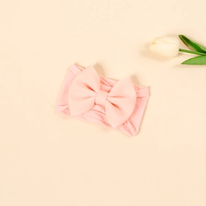 Close-up of a pink soft nylon baby headband with a large bow and 4-inch wide elastic fabric