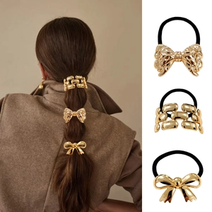 Dreiteiliges Punk-Haarring-Set mit goldenen Metallschleifen und Kettenanhängern an Modellen
