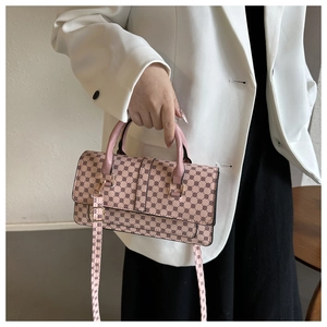 Detail of pink geometric pattern crossbody bag with leather handles and metallic hardware