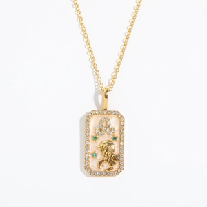 Detail of gold Leo zodiac necklace with pink enamel and sparkling crystal border