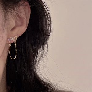 Detailed close-up of vintage luxury earrings with purple crystals and gold bead tassels