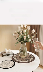 Detail of French vintage floral absorbent leather vase mats for desk protection