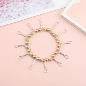 U-shaped gold pearl scarf clips for hijab and shawls on a soft pink background