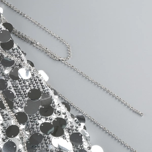 Detailed view of silver sequins and rhinestone chain on mesh fabric evening dress