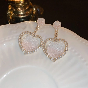 Macro shot of heart-shaped gradient earrings with gold settings and pave-set zircons